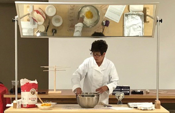 People in kitchen learning how to cook.